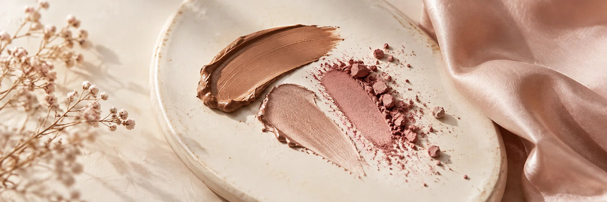 Elegant soft mocha and muted rose pigment strokes on ivory ceramic beside a folded blush silk edge, subtle and understated daylight.